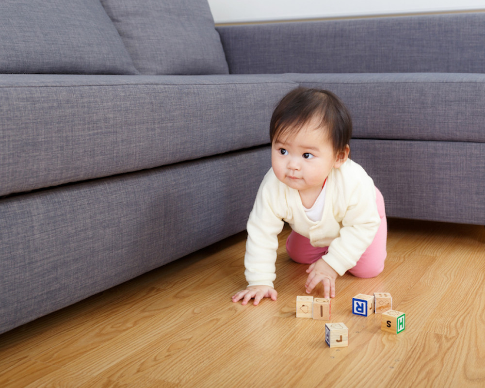 Baby playing with blocks on a wood floor